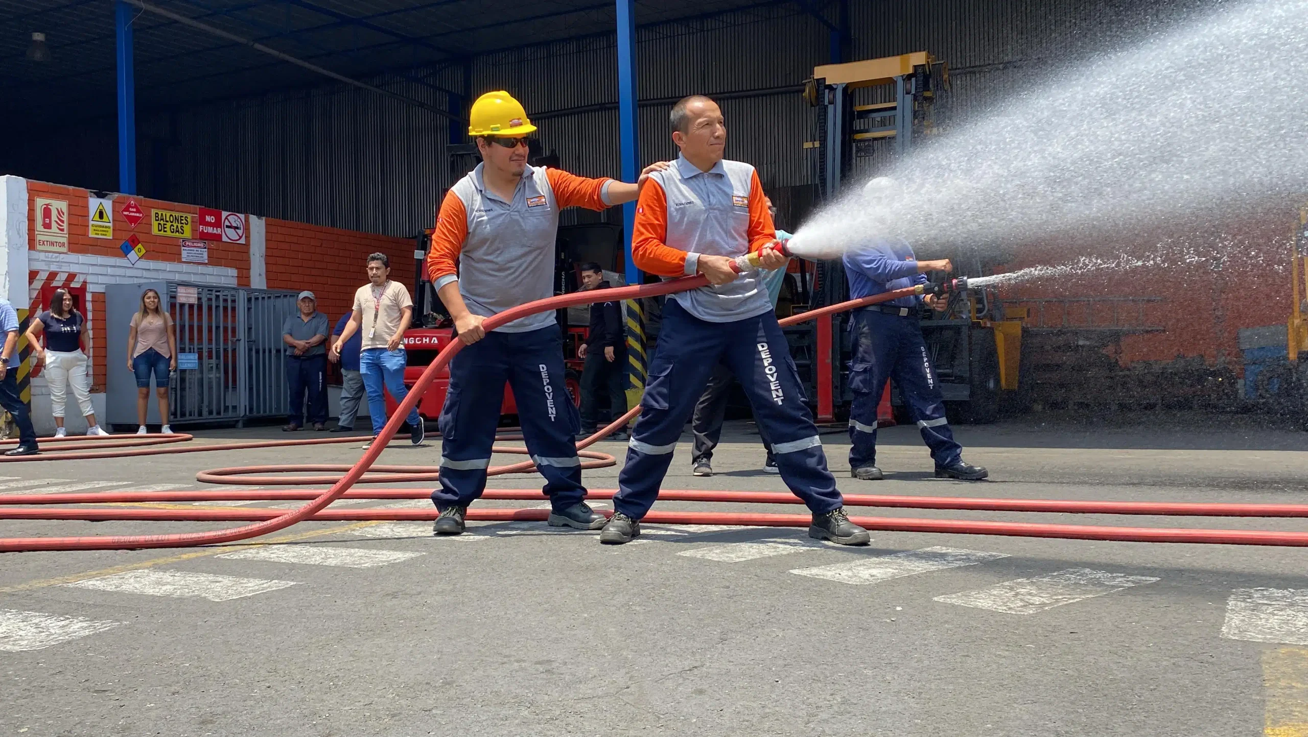 Personal de Depovent participando en un simulacro con mangueras contra incendios